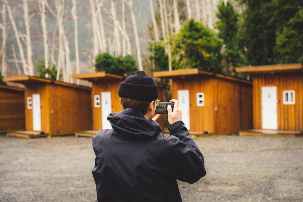 A person taking a photo of sleeping huts