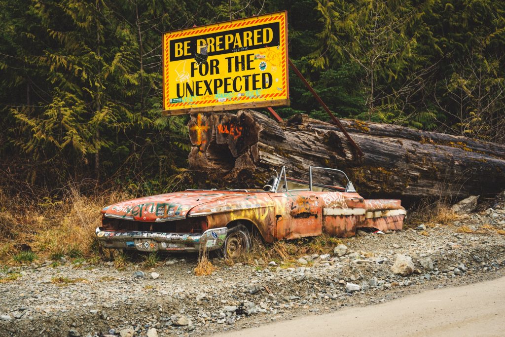 A warning sign on a backroad stating to "Prepare for the Unexpected"